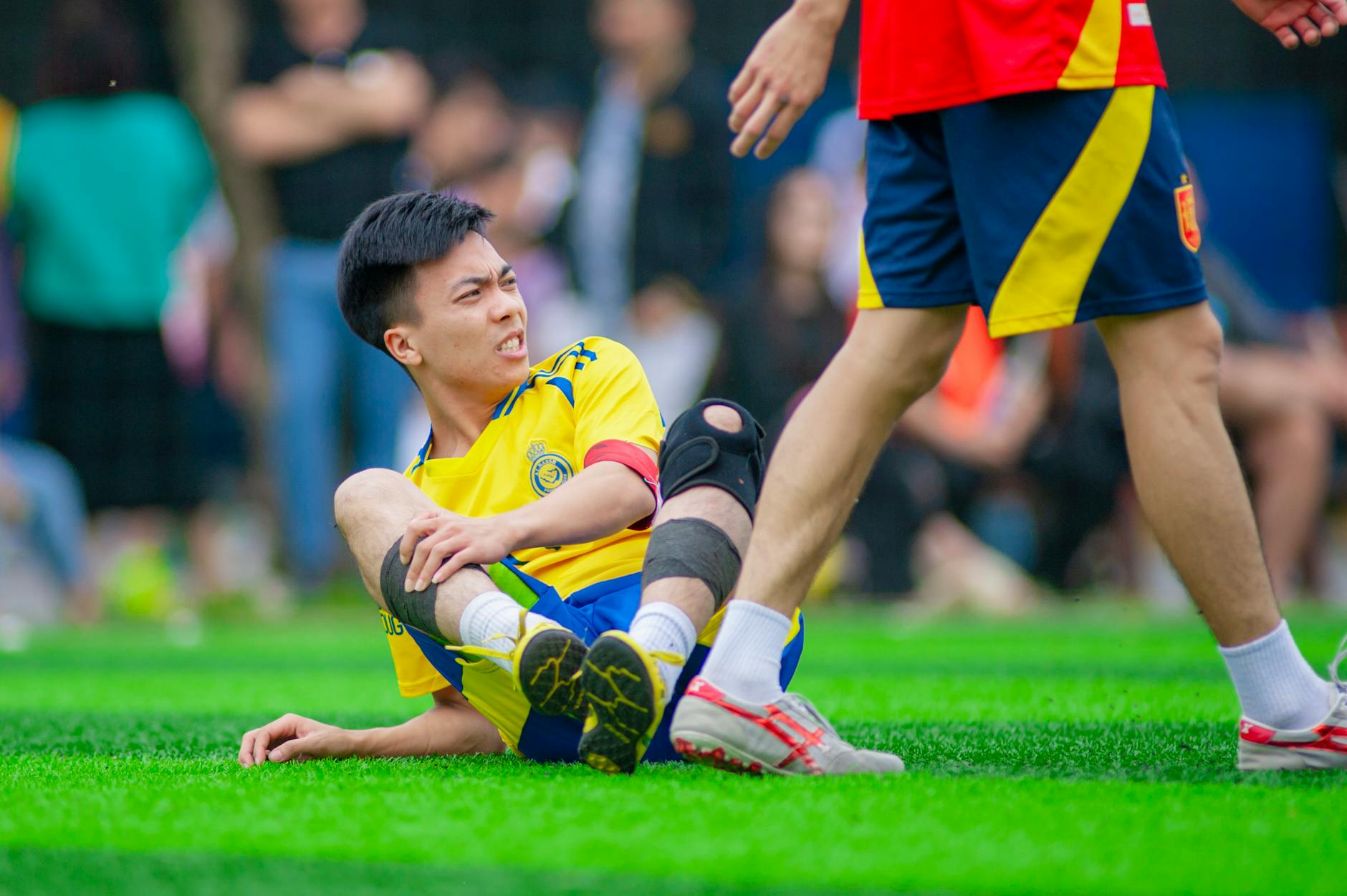 Centermedical dla aktywnych: stabilizatory i ortezy sportowe, które chronią przed kontuzją Piłkarz leży na murawie i trzyma bolące kolano podczas meczu